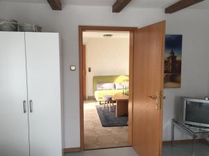 Puerta a un dormitorio con cama y TV en Historical Apartment, en Gummersbach
