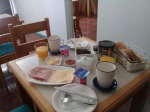 stół ze śniadaniem i napojami w obiekcie Hostal Casa Azul w mieście Talca