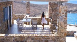 a woman in a white dress walking on a porch at Cape Suites in Kithnos