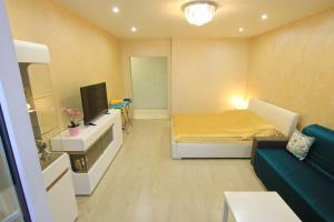 カリーニングラードにあるVIP Apartment с кондиционером в престижном районеのベッド1台とソファが備わる小さな客室です。