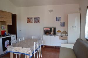 アリエントゥにあるAppartamento a Vignola Mareのキッチン(テーブル、白い冷蔵庫付)