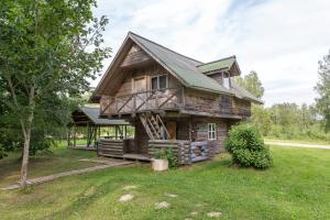 a log cabin with a gambrel roof at Atpūtas komplekss Kalves in Mordanga