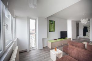 uma sala de estar com um sofá e uma televisão em RiverView apartment em Osijek