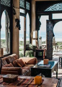 een woonkamer met een bank en een tafel bij Dar Danse, the Bubble on the Beach in Zaouia Akermoud