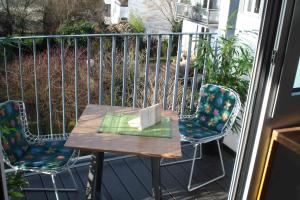 a table and two chairs on a balcony with a laptop at Lovely Studio in Cannstatt in Stuttgart