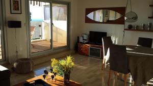 a living room with a dining room table and a balcony at Très bel appartement vue mer à Nice in Nice