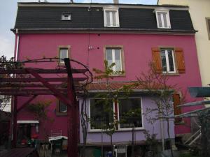 una casa rosa con techo negro en La Baraque, en Colmar