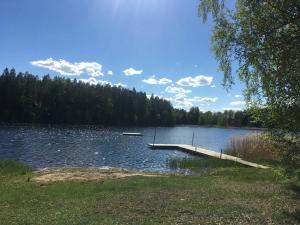 a dock on a lake with a boat on it at Sättraby villa in Norrtälje