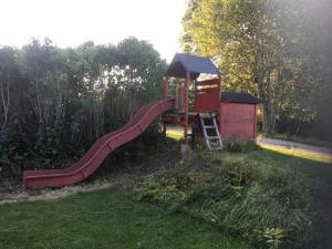 a small playground with a slide in the grass at Sättraby villa in Norrtälje