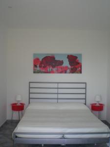 un letto in una stanza con due tavoli rossi di Villa Manatí a Maratea