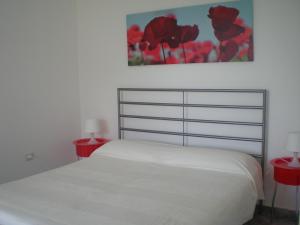 マラテーアにあるVilla Manatíのベッドルーム1室(白いベッド1台、赤いテーブル2台付)