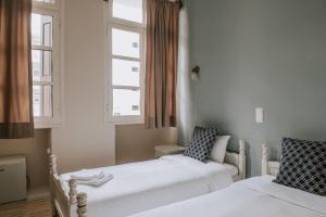 two beds in a room with two windows at Faidra in Chios