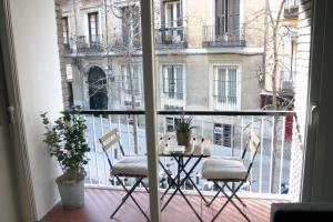 einen Tisch und Stühle auf einem Balkon mit Fenster in der Unterkunft Espejo Mágico in Madrid