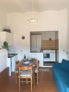 een keuken en een woonkamer met een tafel en een blauwe bank bij Anna's Place in Capoliveri
