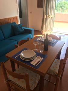 een eettafel met borden en wijnglazen erop bij Anna's Place in Capoliveri