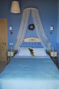 a blue bedroom with a large bed with blue walls at Thea Thalatta Villas in Tsoukaladhes