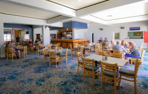 une salle à manger avec des tables, des chaises et des personnes dans l'établissement Esplanade Hotel Busselton, à Busselton