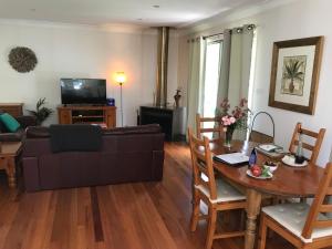 een woonkamer met een bank en een tafel bij Ghost Hill Road Retreat in Bilpin