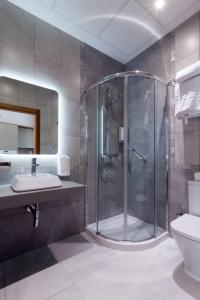 y baño con ducha, aseo y lavamanos. en Casa Gloria Apartments, en Sevilla