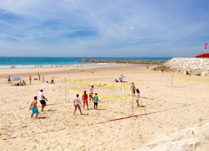 コスタ・ダ・カパリカにあるTHE BEACH! Caparica Concept Apartments!の浜辺でサッカーをしている人々の集団