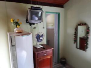 einen TV auf einer Kommode in einem Zimmer in der Unterkunft Suítes Dona Ilda in Pirenópolis