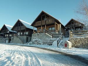 uma grande casa de madeira com neve no chão em Chalé | Penhas da Saúde - Serra da Estrela em Penhas da Saúde