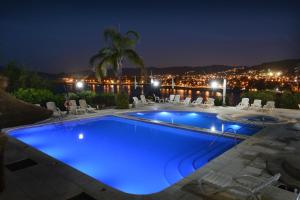 a swimming pool lit up at night at Hotel Marqués del Lago in Villa Carlos Paz