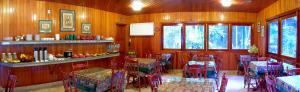 ein Restaurant mit Holzwänden, Tischen und Stühlen in der Unterkunft Hotel Akaskay in Nova Friburgo