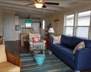 a living room with a blue couch and chairs and a kitchen at donovan"s Reef in Oak Island