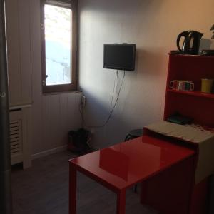 ラ・モンジーにあるStudio la mongieの赤いテーブルと窓のある部屋