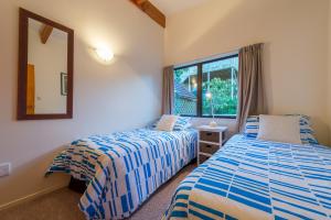 a bedroom with two beds and a window at By the Bay Beachfront Apartments in Mangonui