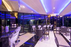 un restaurante con un bar con mesas y sillas en PSG Hotel en Udon Thani
