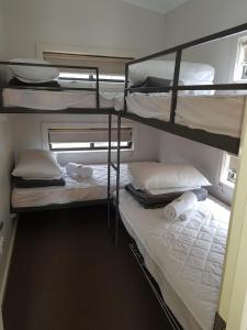 a bedroom with two bunk beds with white sheets and towels at Yarrawonga Riverlands Tourist Park in Yarrawonga