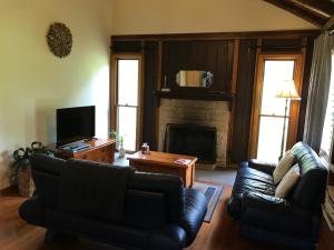 a living room with a couch and a fireplace at Ghost Hill Road Retreat in Bilpin