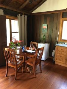 - une salle à manger avec une table et des chaises en bois dans l'établissement Ghost Hill Road Retreat, à Bilpin