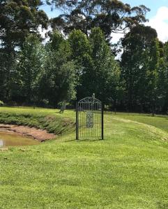 a bird cage in the grass in a park at Ghost Hill Road Retreat in Bilpin