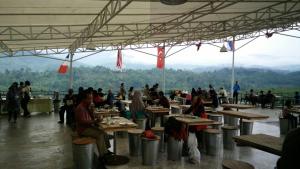 a group of people sitting at tables in a building at Bravo Adventure Glamping in Gunungmalang
