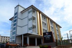 un bâtiment avec un panneau devant lui dans l'établissement Ketsara Hotel, à Maha Sarakham