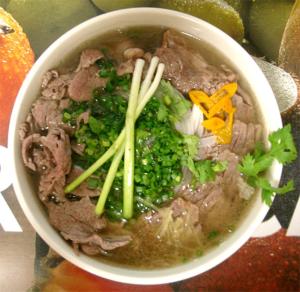 a bowl of soup with meat and vegetables on a table at Mely Hotel Hà Nội in Hanoi