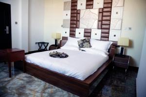 a bedroom with a large bed with a wooden headboard at Afropolitan Hotel in Addis Ababa
