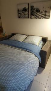 - un lit avec des draps et des oreillers bleus dans l'établissement Nice France, à Nice