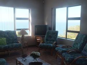 a living room with two chairs and a television at Sieniesee in Mossel Bay