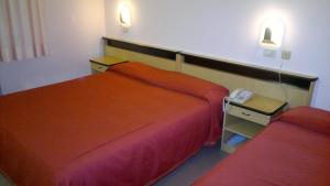 a hotel room with two beds and a phone at Hotel Centrale in Argenta
