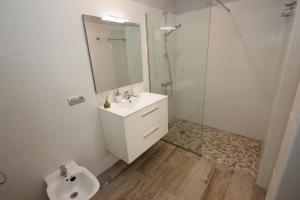 Un baño blanco con lavabo y ducha. en Apartments FIBAN Finca SanJuan Batista, en Guía de Isora 12 fotos más