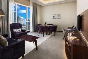a living room with a table and a dining room at Radisson Blu Hotel, Dubai Waterfront in Dubai