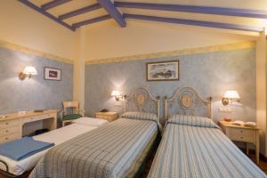 two beds in a bedroom with blue and white at Condesa de Chinchón in Chinchón