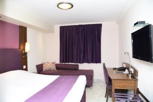 Cette chambre comprend un lit et un bureau. dans l'établissement Caspia Hotel New Delhi, à New Delhi