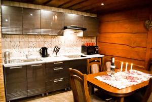 Il comprend une cuisine équipée d'une table, d'un évier et d'une cuisinière. dans l'établissement Apartmán u Žanety, à Ždiar