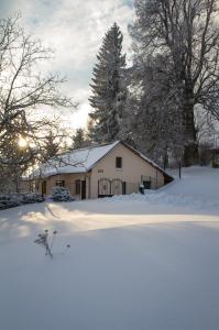 een huis met sneeuw op de grond ervoor bij Burg nad Banskou Štiavnicou in Štiavnické Bane