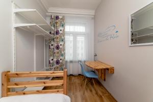 a bedroom with a bed and a wooden desk at Orange Cat Rooms in Riga
